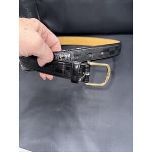 black leather belt with a gold-tone buckle and a checkered pattern